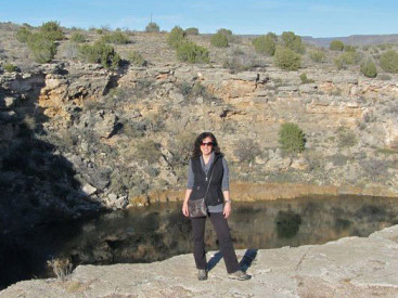 Ingram stands in front of an Arizona sinkhole known as the Montezuma Well. It served as a water source for the Sinagua people until they disappeared from the area around AD 1300.