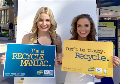 two students with recycling signs