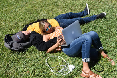 Couple with laptop relaxing on lawn