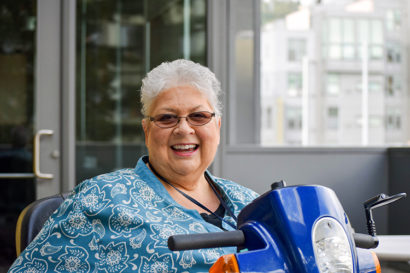 A photo of Je Nell Padilla sitting on her mobility scooter