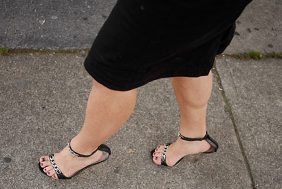 A photo of woman walking from the legs down