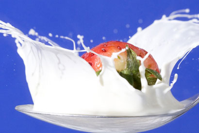 milk and strawberry in a spoon