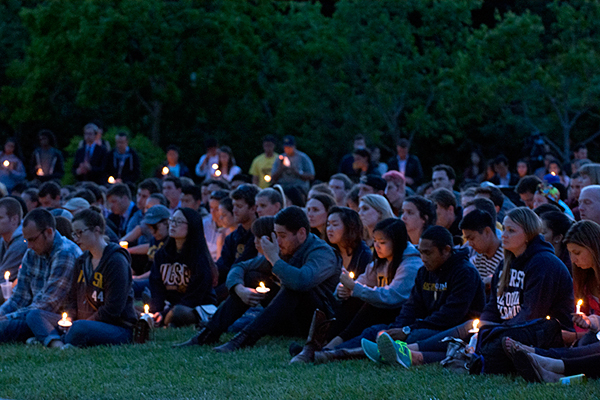 student holding candles in dark