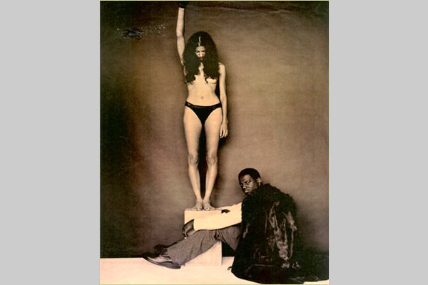 Woman in underwear giving power salute, with R&B artist Brian McKnight