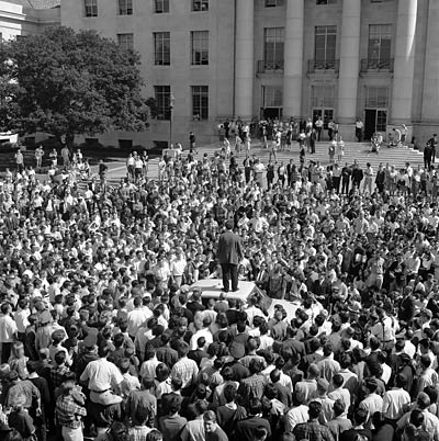 Mario Savio stands on top of a car in front of Sproul Hall