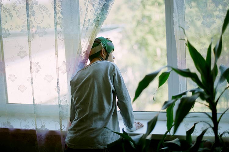 photo of boy looking out of window