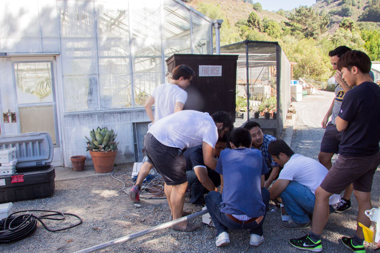 students working on sensors near greenhouse