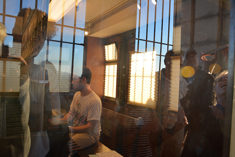 A carillon student sits at the keyboard inside the playing cabin on the Campanile's observation deck.