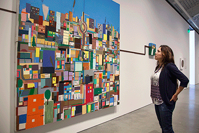 In BAMPFA, senior Brenda Romero admires a Chris Johanson painting, Cityscape with House & Gray Energy. (UC Berkeley photo by Brittany Murphy)