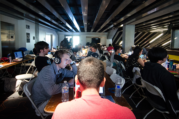 Approximately a dozen people work at computer monitors