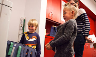 Two children watch as the pages of a storybook is printed