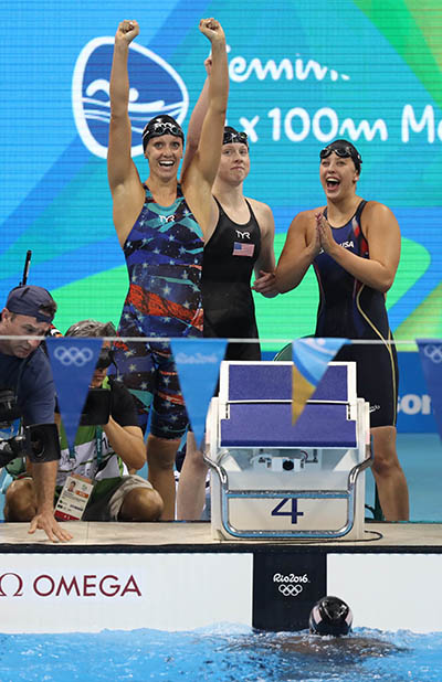 Dana Vollmer (left) and Kathleen Baker (right) cheer with Lilly King after winning, along with Simone Manuel (in pool), the women's 4x100 medley relay final in Rio. (USA Today Images photo)