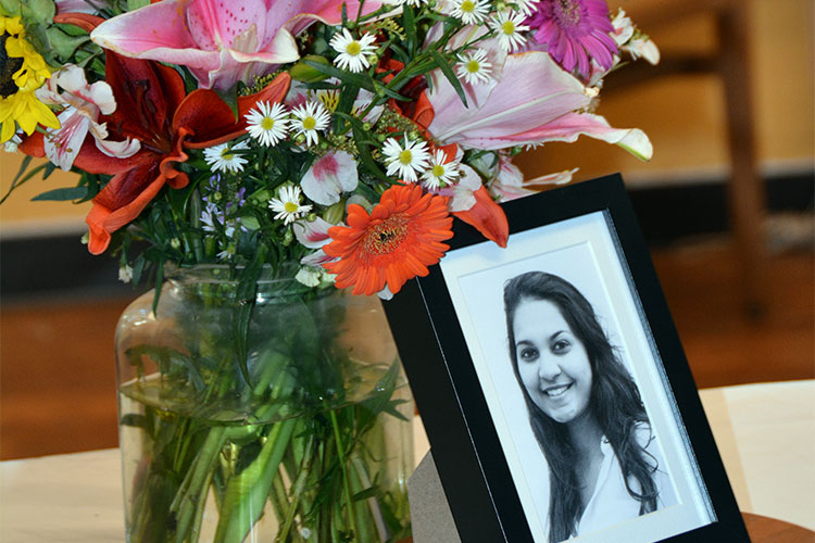 A photo of Tarishi Jain placed next to a vase of flowers to honor her after her death in a terrorist attack in Bangladesh.