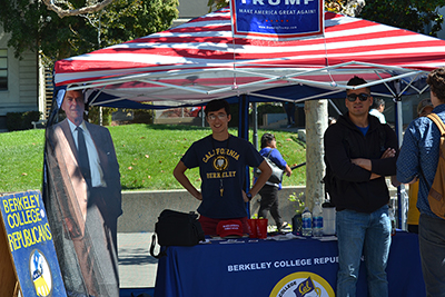 Two undergraduate students stand at Berkeley College Republicans booth near Sather Gate.