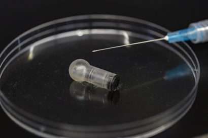 Mucojet capsule in a petri dish next to a syringe