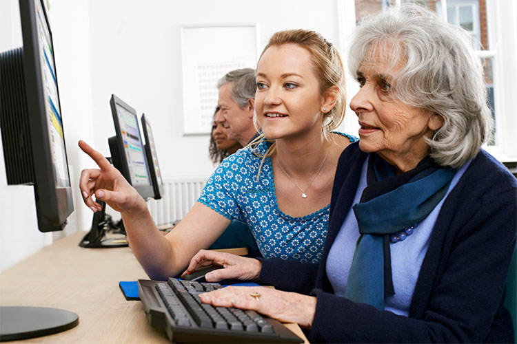 two women at a computer, one young, one older