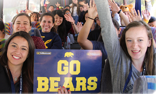 Students on the Golden Bear Express bus holding a 'Go Bears' sign.