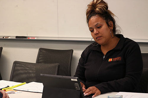 Patricia Figueroa sitting with a laptop during a session and helping students sign up for CalFresh at Berkeley.