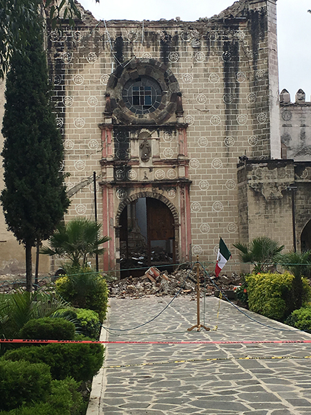 The Ex Convento de San Guillermo in Totolapan, heavily damaged by the Sept. 19 earthquake, with rubble piled near its entrance and a Mexican flag nearby.