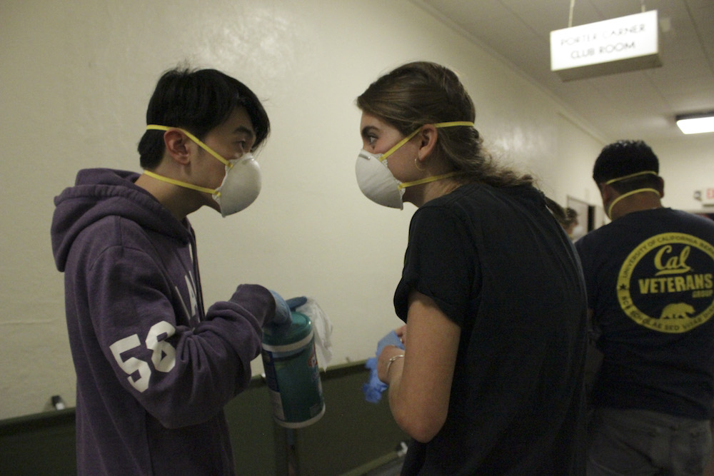 Rocky Li and Allie Jones, two public health students, talk as they sanitize door knobs at a evacuation center in Santa Rosa on Friday. (UC Berkeley photo by Jeremy Snowden)