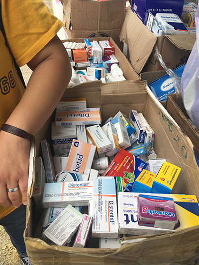 Boxes filled with donated medicines waiting to be sorted and distributed at a relief center.