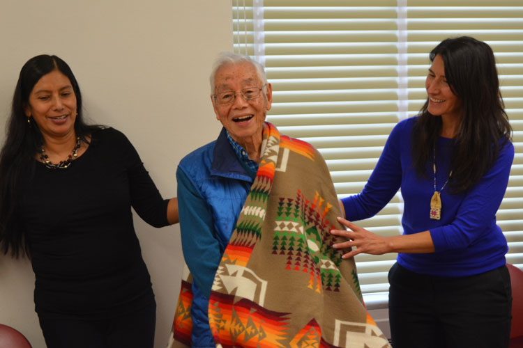 Haruo Aoki stands between Piatote and Sobotta, receiving a blanket from the Nez Perce scholars. Haruo is a professor emeritus of East Asian languages.