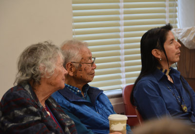 UC Berkeley linguists sit around a table listening intently to a speaker.