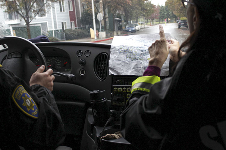 Terri Castenada, a police business clerk, gives directions to UCPD Captain Alex Yao while they deliver turkeys in University Village. (UC Berkeley photo by Jeremy Snowden)