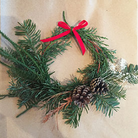 Holiday evergreen wreath with pinecones and a red bow