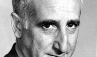 Close up of Ben Bagdikian's face as he gazes into the camera. 