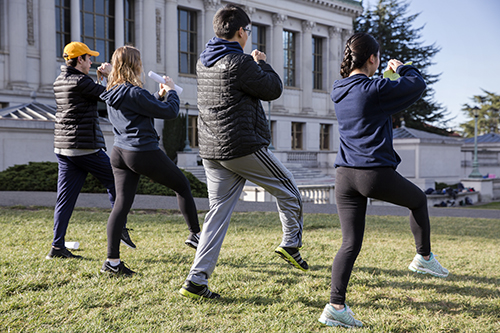 Four Cal Band members practice marching without instruments.