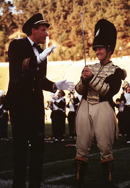 Erin Proudfoot, drum major in 1995, smiling at band director Bob Calonico during a Cal Band performance.