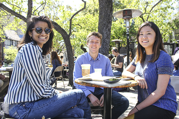 Three members of the Archer team sitting outdoors at a café.