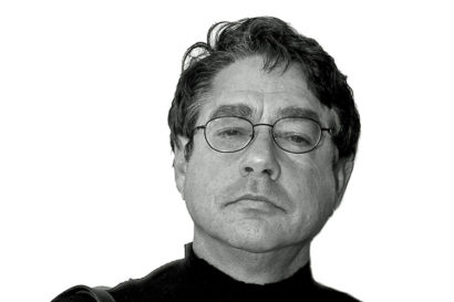 black and white portrait of Mel Gordon wearing glasses and a black turtleneck sweater