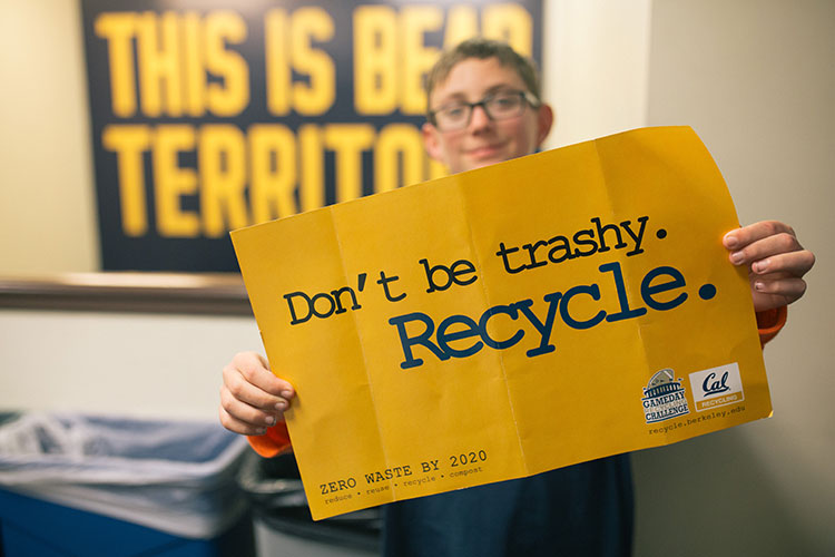 student with recycle sign