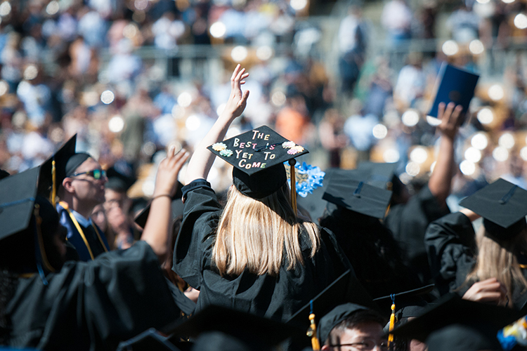 graduates waving