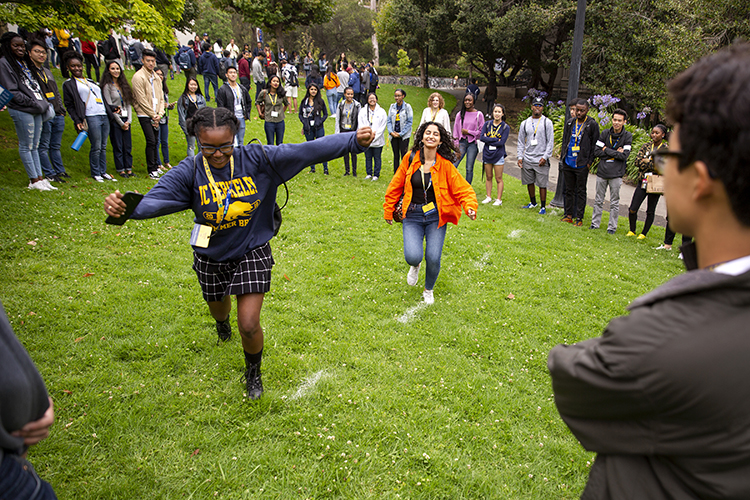 students run across field with arms out