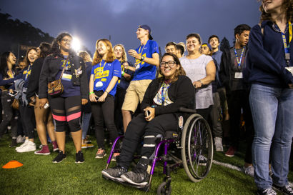 student mariana soto-sanchez on a field smiling with more than a dozen other students