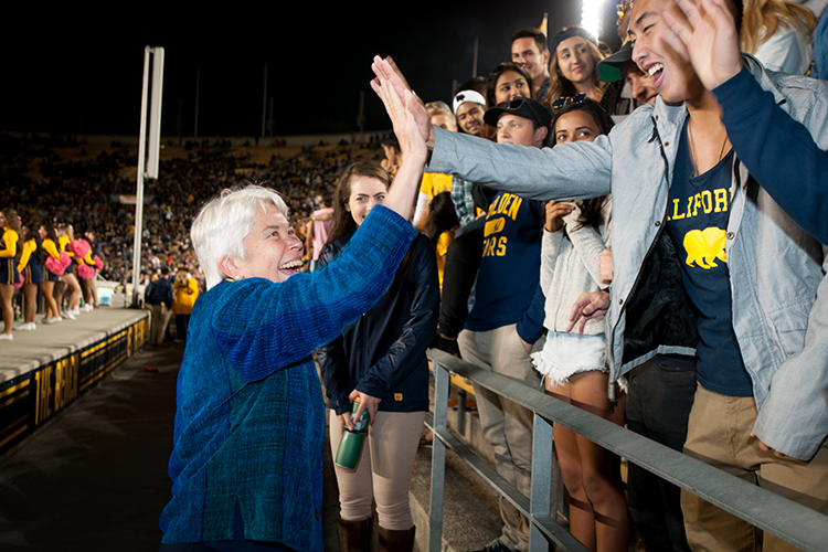 Chancellor Carol Christ smiles and high fives students