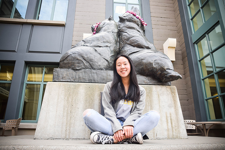 Campus ambassador Celene Chen poses with a bear statue on campus.
