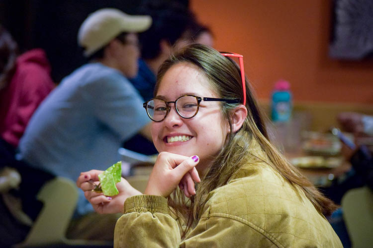 a woman looks at the camera while holding food