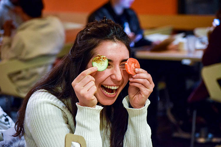 a woman holds vegetables in front of her eyes