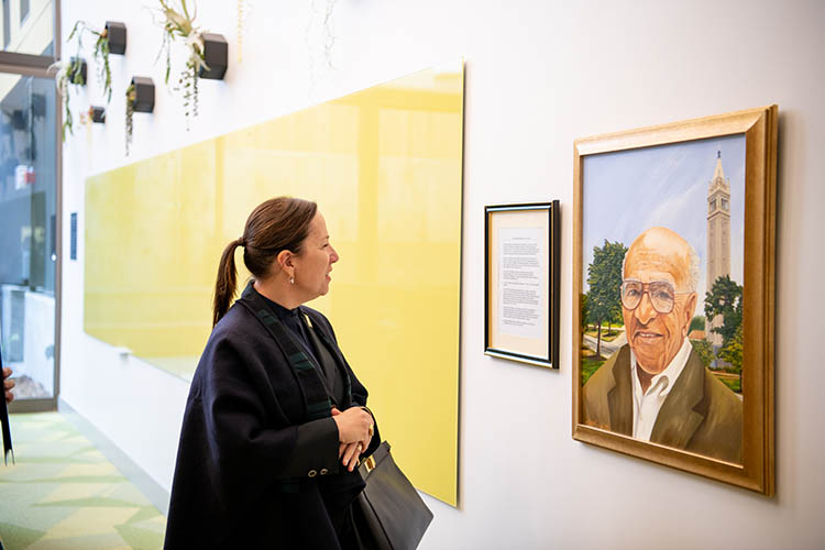 a woman looks at a portrait