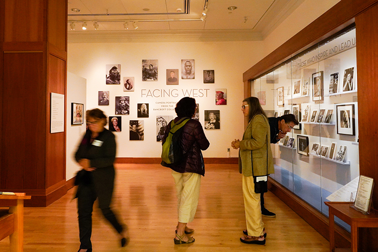 visitors look at photos on exhibit