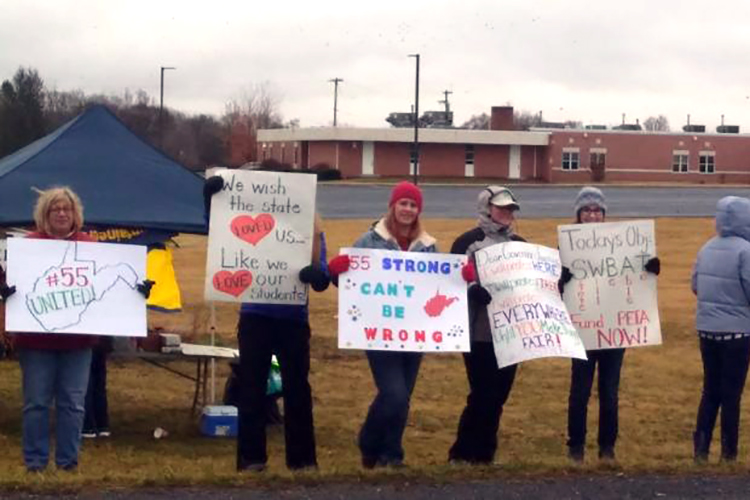 teachers on strike holding signs