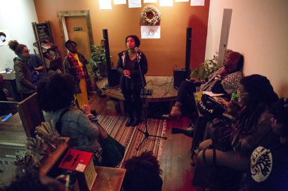 People gathered around a woman speaking into a microphone