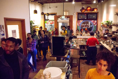 An image of the aforementioned cafe in full service with people waiting in line and employees bustling to work.