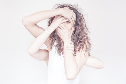 A woman with four hands are her face covering her mouth and one eye