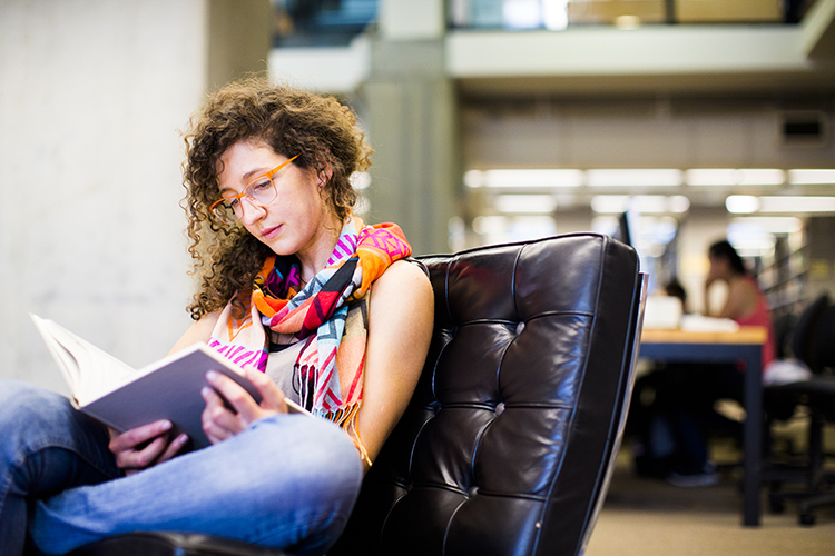 a student reads a book in a chair