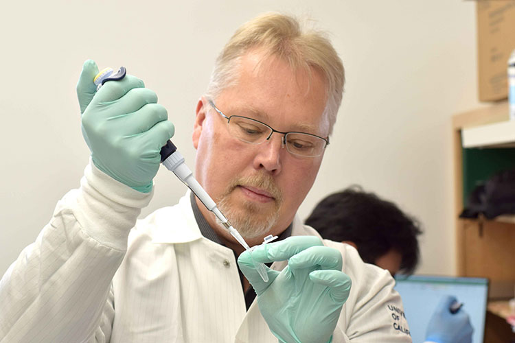 Anders Naar pipettes liquid into a test tube.